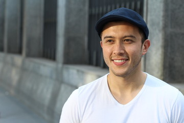 Young Hispanic male smiling outside looking away
