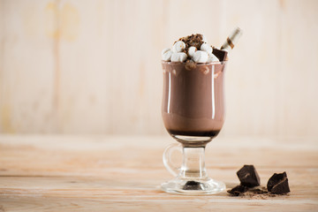 chocolate milkshake with marshmallows and sweet straw in glass on tabletop
