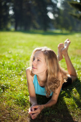 Obraz premium Young girl enjoying relaxation lying in the fresh green grass