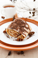 Piece of apple pie strewn grated chocolate with tea