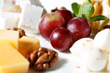 Cheese in the assortment of grapes and walnuts