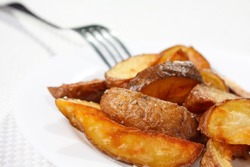 Potato wedges roasted in their skins on a plate