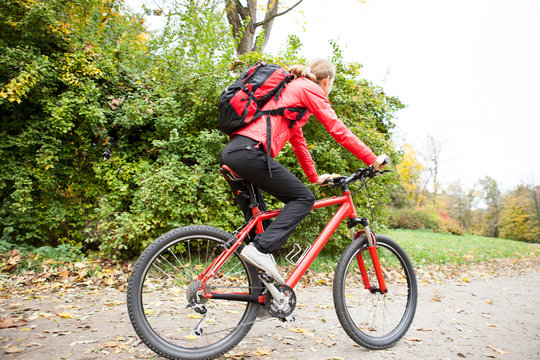 Woman cyclist riding a bike in autumn park