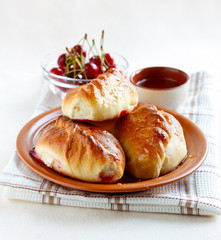 Sweet patties with cherry on a rustic plate soaked in honey