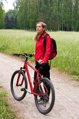 Woman cyclist on a bicycle walk on the green nature