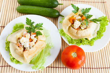 Two Salad with boiled vegetables wrapped in a pancake on a plate