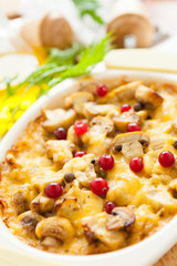 Vegetables casserole with mushrooms, potatoes, cranberries and cheese on a pan