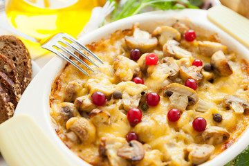 Vegetables gratin with mushrooms, potatoes, cranberries and cheese