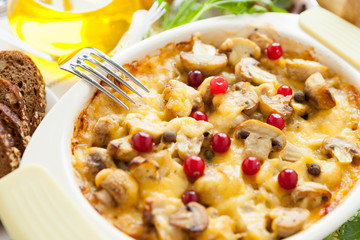 Vegetables gratin with mushrooms, potatoes, cranberries and cheese on a pan