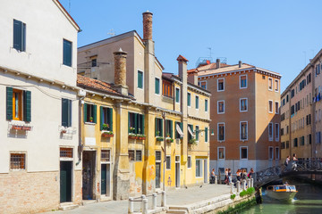 Fototapeta premium VENICE, ITALY - May 18, 2017. Tourists foot Street in Venice. its entirety is listed as a World Heritage Site, along with its lagoon. VENICE, ITALY.