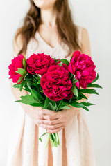 Young woman holding in hands peony bouquet. Sweet romantic moment