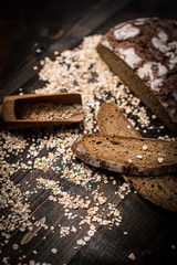 Traditional Whole Grain Rye Bread on Dark Wooden Table Background