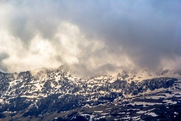 Fototapeta na wymiar Горный пейзаж, красивый вид на живописное ущелье, высокие снежные склоны, облачное небо над горами, природа Кавказа, Грузия