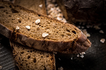 Traditional Whole Grain Rye Bread on Dark Wooden Table Background