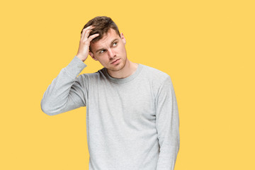 Tired businessman or The serious young man over yellow studio background with headache emotions