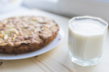 Apple pie on a plate and a glass of milk