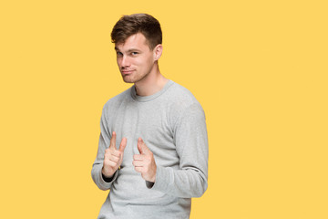 The young man smiling and looking and pointing at cameraaway