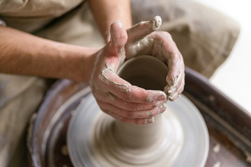 Hands working on pottery wheel