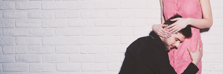 Loving man kneeling embracing girlfriend