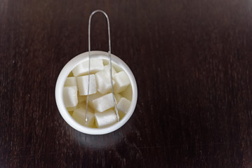 Sugar cubes in sugar bowl and sugar tongs