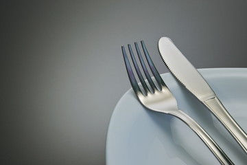 Fork and knife on a grey background
