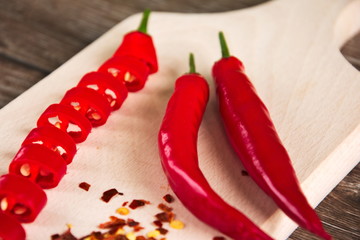 Red hot chilli peppers sliced on a wooden chopping board