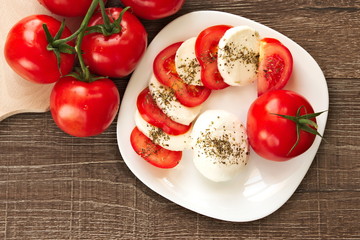 Fresh tomato with mozzarella cheese on a white plate