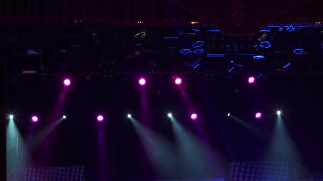 Lighting equipment in action on stage. Colorful stage lights at concert.