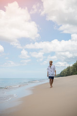 Fototapeta na wymiar Young man walk alone on the beach.