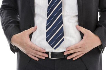 お腹に手をあてるスーツ姿の男性