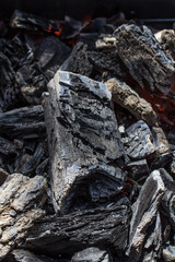 Glowing black charcoal texture background close up