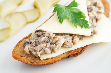 toast with mushroom caviar and cheese served with pickled cucumber and decorated with parsley leaf