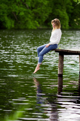 Beautiful girl sitting on the pier