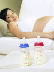 Obraz na płótnie Canvas pregnant woman looking at milk bottles