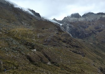 Thin hiking trail navigating the open alpine terrain below a couple of large glaciers