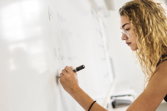 Student (14-15) writing on whiteboard
