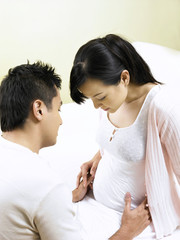 husband checking pregnant wife tummy