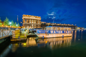 A water taxi along the Fells Point Waterfront at night, in Baltimore, Maryland.