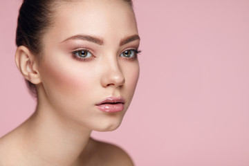Fototapeta premium Facial Beauty Makeup. Woman With Fresh Face On Pink Background