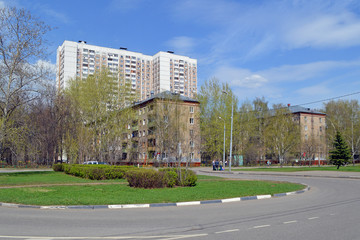 Пятиэтажные четырёхподъездные кирпичные жилые дома в Москве на фоне многоэтажного дома 