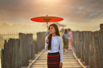 The beautiful woman Myanmar in U-ben bridge on during sunrise , treaditional culture myanmar,Mandalay Myanmar