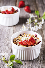 Strawberry blackberry crumble with oatmeal crispy crust on vintage rustic wooden table. Healthy breakfast. Summer baking. Diet. Selective focus 