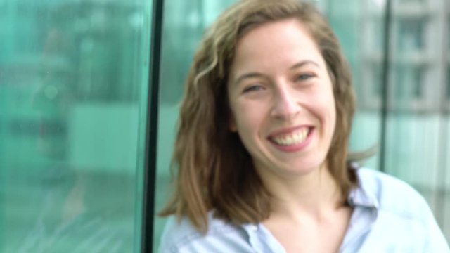 Young woman smiling cheerfully outdoors, portrait