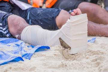 first aid by elastic bandage around right leg