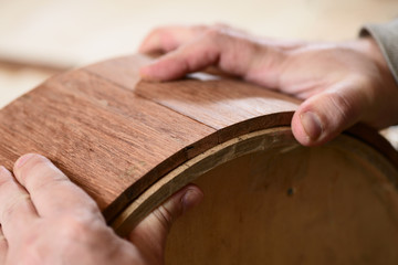 Carppenter hands making merbau wood shell for drum