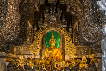 Abstract golden Buddha statue with silver metal frame in temple at Wat Sri Suphan Chiang Mai, Thailand