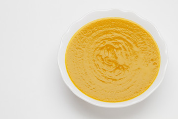 Plate of pea cream soup on white background