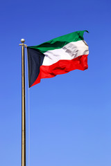 Fototapeta na wymiar Waving National Flag Of Kuwait On A Blue Daytime Sky