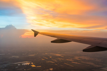 Sunset in twilight time with Wing of an airplane and cloud sky. Photo applied to tourism operators. picture for add text message or frame website. Traveling concept