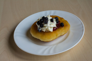 Sweet homemade donut with jam and whipped cream and blueberries